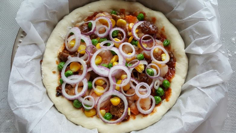 鸡肉海鲜披萨,17．上面装饰青豆，玉米粒和洋葱圈。