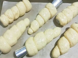 紫薯芋泥螺卷包,将发酵好的面包胚取出，刷上一层蛋液再洒点白芝麻，放入预热好的烤箱中层上下火170度烤约15~20分钟即好； 