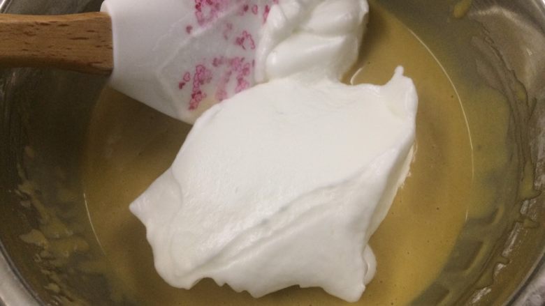 冷萃咖啡蛋糕卷,勺三分之一蛋白霜与蛋黄糊混合均匀。