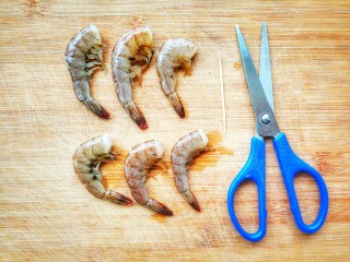 清爽无负担的鲜虾牛油果藜麦饭,蒸米饭的过程中，我们来处理食材，鲜虾去头，用剪刀开背，再用牙签挑去虾线，