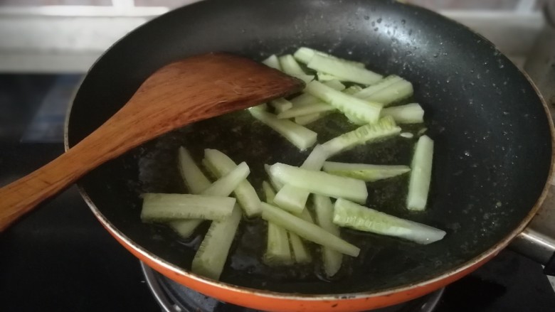 木耳黄瓜炒虾仁,锅里继续放入油，放入黄瓜条，炒软