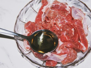 铁板黑椒牛柳,腌牛肉，首先放入一勺料酒
