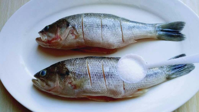 #无肉不欢#家常红烧小鲈鱼,将洗干净的鱼放在鱼盘里，撒上盐。