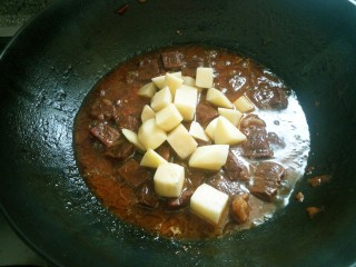 红烧牛肉炖土豆,放入土豆。