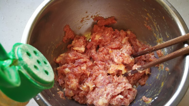 #咸味#莲藕猪肉丸,加入适量的胡椒粉，用筷子搅拌均匀。