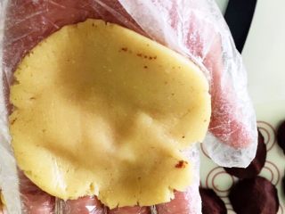 传统广式豆沙月饼,取一个饼皮，轻轻的压成中间薄四周厚一点的圆