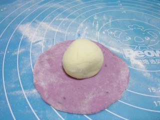 花样馒头,将紫薯面团擀成圆皮，将才面团放到擀好的紫薯面团上。