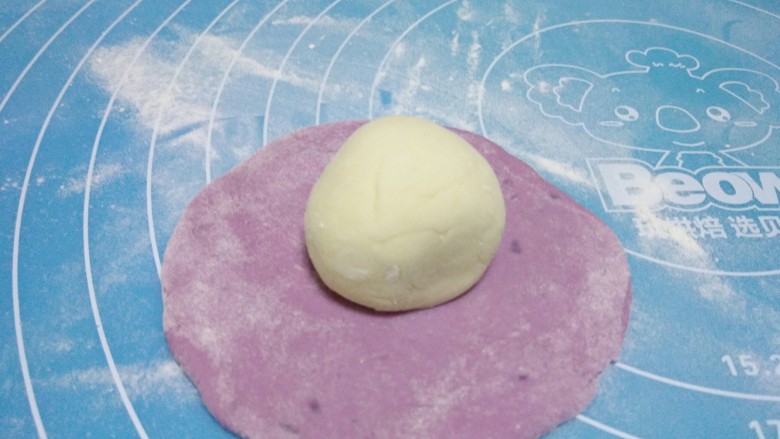 花样馒头,将紫薯面团擀成圆皮，将才面团放到擀好的紫薯面团上。
