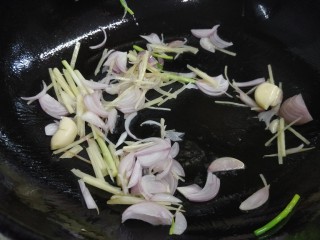 酱香茶树菇炒牛肉,锅内热少许油，放入姜、蒜、红葱头、葱白中火炒出香味。
