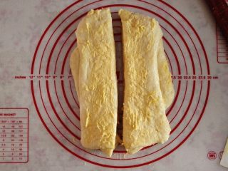 奶黄馅吐司,用擀面杖擀成长方形，把剩余的奶黄馅都涂抹在上面，用刮刀从是间切开，