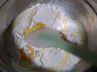 原味蛋糕卷,蛋黄盆，利用刮刀，搅拌至无干粉细腻的状态