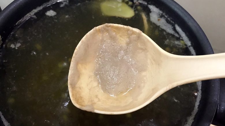 清热解毒的绿豆排骨汤,期间用勺子撇去浮末