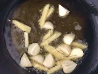 金钱菇炖土鸡,胡麻油入锅烧到7成热，放入姜蒜，煸出香味。