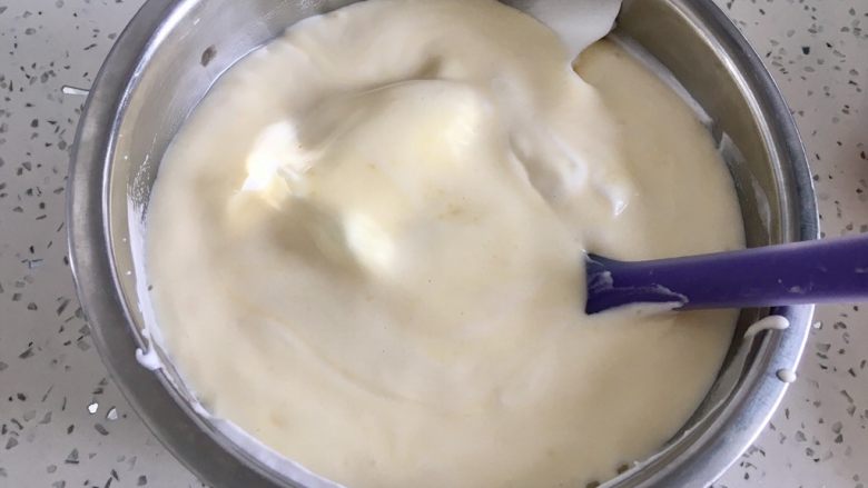 虎皮蛋糕卷,把翻拌好的蛋黄糊放入蛋白霜盆里，用刮刀翻拌均匀。