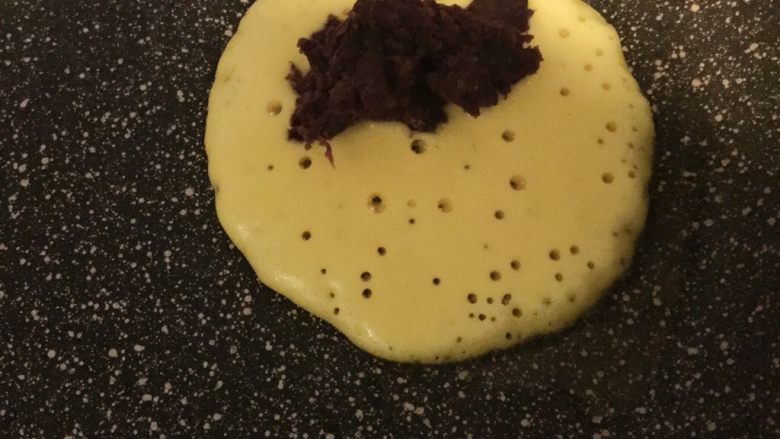 紫薯玉米面饼,一会会发现面饼有许多小孔，然后在一边放入紫薯泥