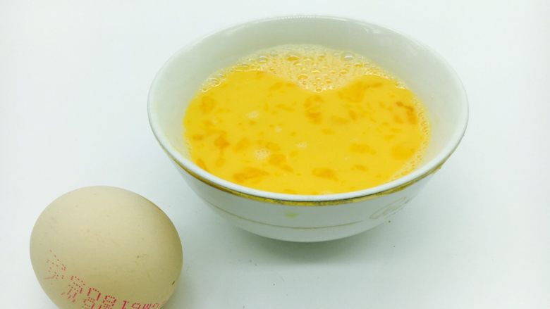  #咸味# 蔬菜蛋炒饭,把鸡蛋打散，搅拌均匀。