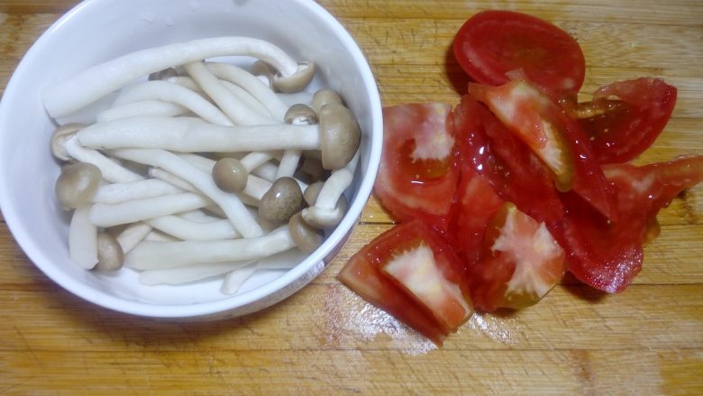 鲜味西红柿肉丸汤,在等待肉丸熟的过程中，来准备配菜，把海鲜菇去根，<a style='color:red;display:inline-block;' href='/shicai/ 3551'>西红柿</a>切滚刀块。