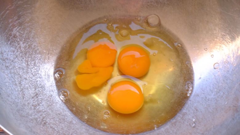 粉嫩可丽卷,将三个鸡蛋敲入盆中