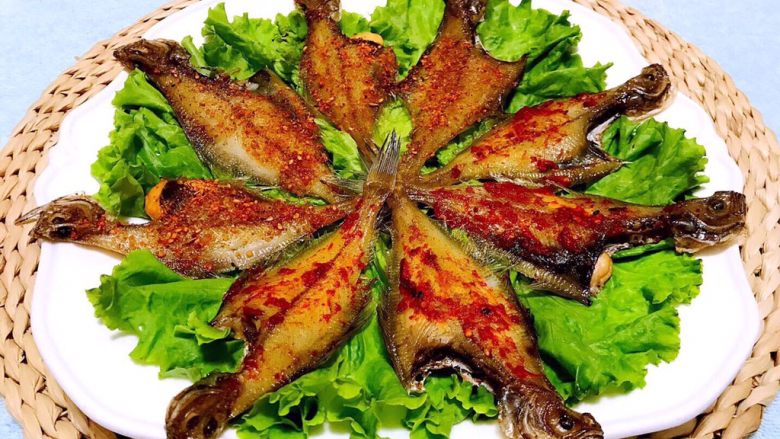 鱼开富贵,将烤好的两种口味的偏口鱼摆入盘中用生菜做装饰