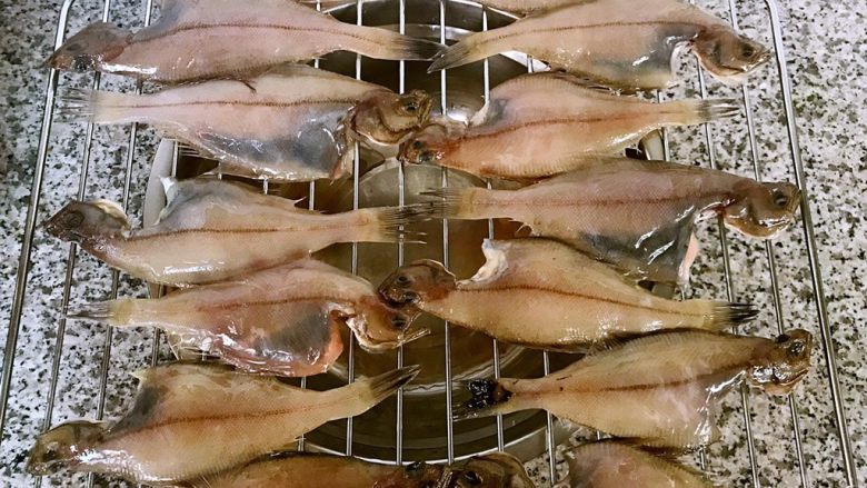 鱼开富贵,偏口鱼摆在烤架上每一条鱼均匀的涂抹上食用油