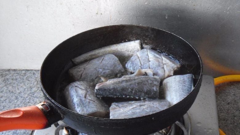 煎烧带鱼, 煎锅热油，放入带鱼段煎制
