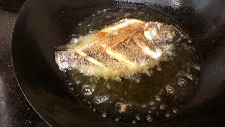 酸甜开胃的糖醋鱼,油烧到七成热，把鱼顺锅边滑入油锅。