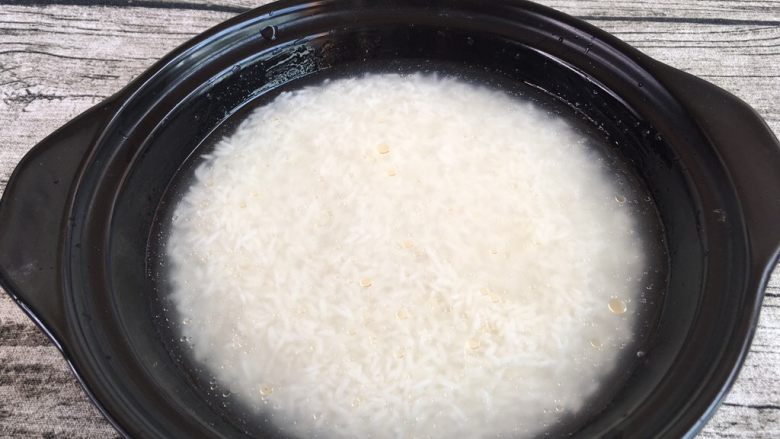 腊肠煲子饭,泡好的米连水一起倒入砂锅内铺平