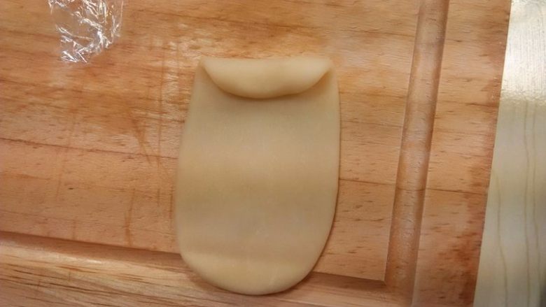 炸荷花酥,擀开成一个牛舌状（擀时要轻点），由上往下卷起来；再擀开，卷起。用同样的方法把红色水油皮做好；