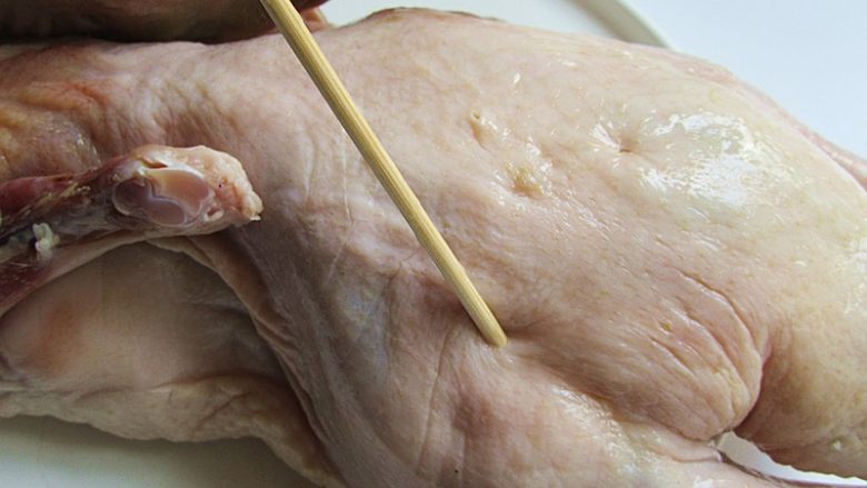 家庭自制脆皮蜜汁烤鸭,先用竹签将鸭子扎一扎，这样可以腌渍更容易入味和烘烤