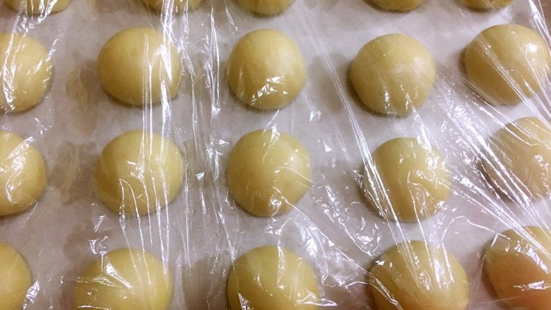 酥酥酥传统蛋黄酥,所有的都包好后盖上保鲜膜10分钟静置，同时预热烤箱180度