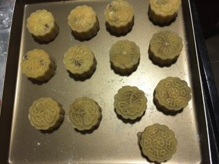 蔓越莓椰蓉月饼,拿出来刷第一次蛋液，用毛刷轻轻的刷凸起的部分，烤箱165度烤10分钟