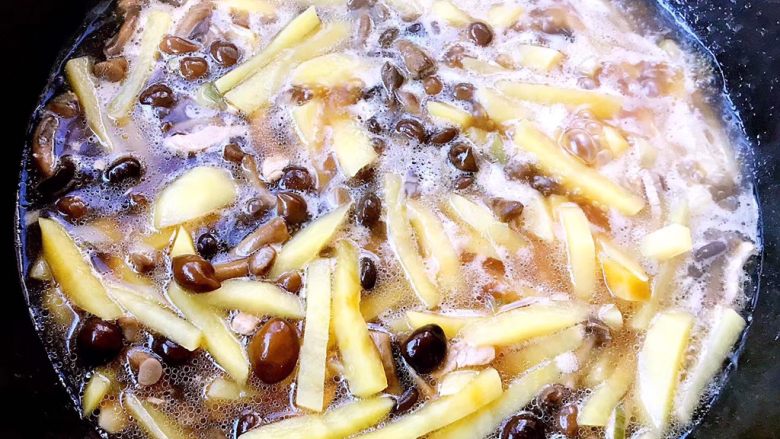 滑子蘑烧土豆,倒入清水或者高汤的同时放入滑子蘑大火炖15分钟