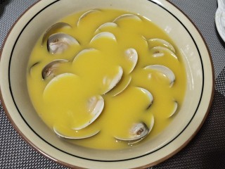 #咸味#文蛤炖蛋,将文蛤稍整理一下，量有点多，应该换个深底的盘来蒸比较好。
盖上保鲜膜，用牙签扎几个小孔