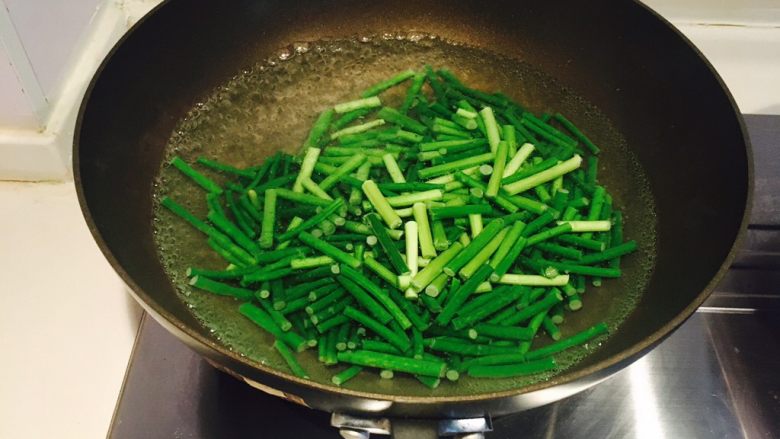蒜苔肉丝,水开，放入蒜苔，撒少许盐，可以保持翠绿