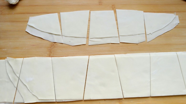 石蛤蟆水饺（博山水饺的包法）,用刀一左一右斜切成相邻颠倒的梯形状。使之成为下底为约08厘米，上底为5-6厘米，高为高为8厘米的等腰梯形面片。