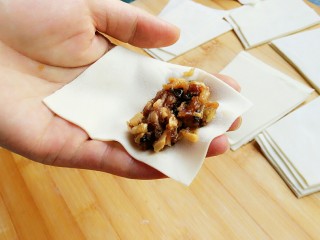石蛤蟆水饺（博山水饺的包法）,开始包饺子，将饺子皮放在伸平的左手掌上，梯形的上底（小头）朝指尖方向。将馅料放在小头的一端。
