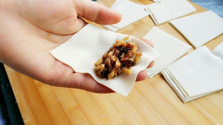 石蛤蟆水饺（博山水饺的包法）,开始包饺子，将饺子皮放在伸平的左手掌上，梯形的上底（小头）朝指尖方向。将馅料放在小头的一端。