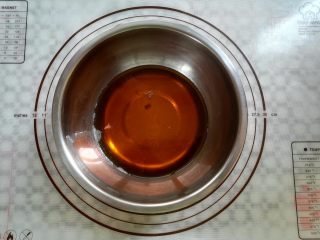 广式红豆沙蛋黄月饼,取一个干净的碗，放入转化糖浆，花生油，枧水