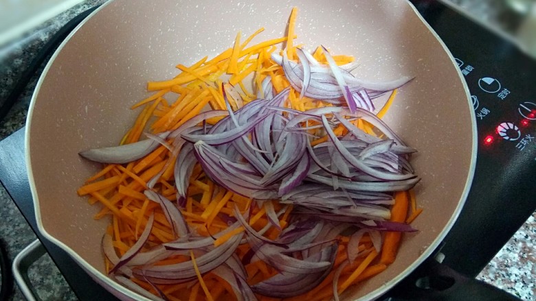 凉拌魔芋丝,放入胡萝卜丝和洋葱丝翻炒，加少许盐调味。