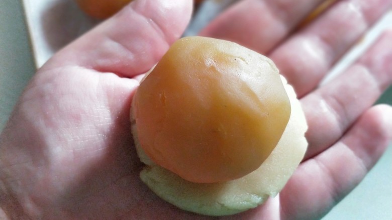 莲蓉蛋黄月饼,将面团按20克每个分好，按扁包裹馅儿，同样是轻推至完全包裹。