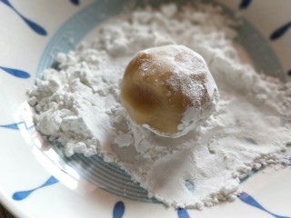 莲蓉蛋黄月饼,将包好的月饼团在盛淀粉的盘子里过一下，拍掉多余淀粉。