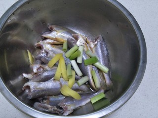 酥炸小黄花鱼,加入胡椒粉少许，葱段和姜片一起加进去，拌均匀后腌制20分钟。