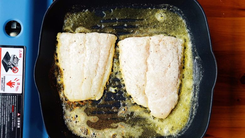 奶油香草龙俐鱼,把20克的黄油放入平底锅，并热锅，待黄油融化后，加入1/2的青柠檬皮碎，把龙俐鱼放进锅里，用小火煎至两面金黄。