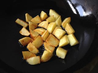 地三鲜,锅中倒入少量油，将土豆块煎至金黄捞出