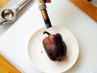 红椒沙拉佐鲷鱼,用火枪将红甜椒的表皮烤焦，以便去掉红甜椒表皮的韧性，并保留里面的水分。（烘烤时，建议使用不锈钢碟子，不能使用烤炉噢~）
