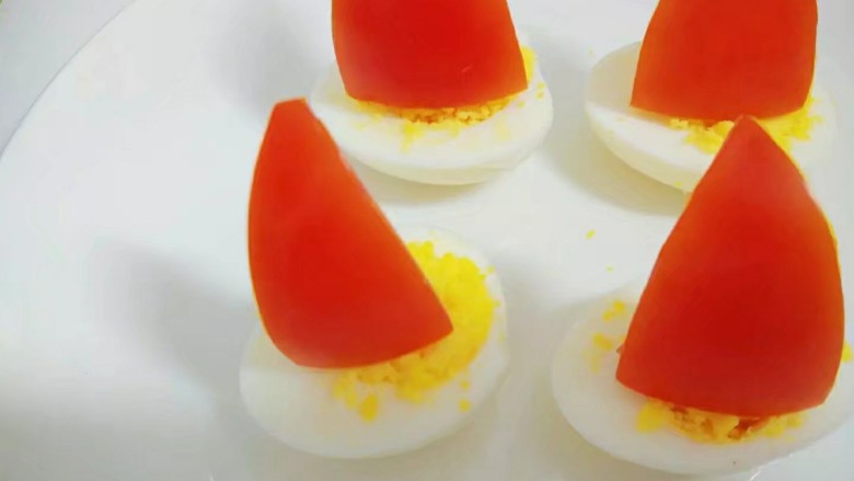 鸡蛋小船,西红柿用牙签固定插在鸡蛋上。