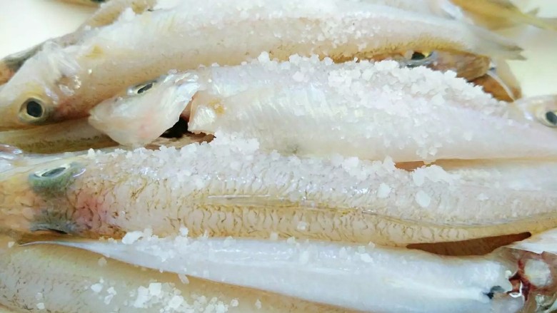 油炸沙尖鱼,洗净的鱼用盐腌制10分钟。