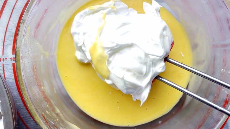6寸爱心戚风（后蛋法）,把三分之一蛋白霜加入蛋黄糊里用蛋抽或刮刀以从下往上翻拌手法翻拌均匀，避免消泡。