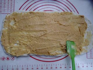 花生奶油核桃卷,用刮刀在面片上均匀抹上花生奶油馅，窄边的最末端不抹，因为沾上油就不好收口了。