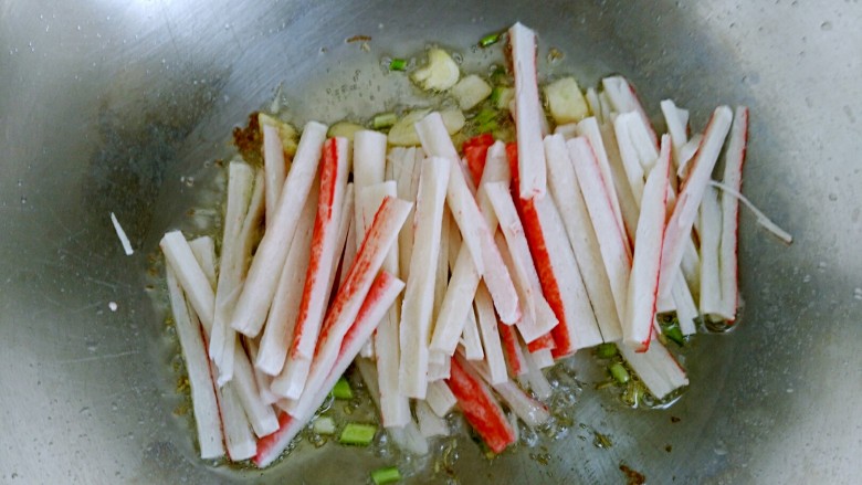 蚝油蟹棒金针菇,倒入蟹棒，翻炒均匀。